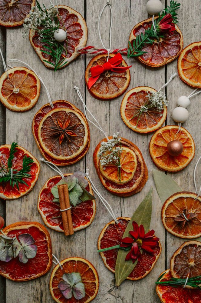 an assortment of orange slices and cinnamons on a table with christmas decorations around them