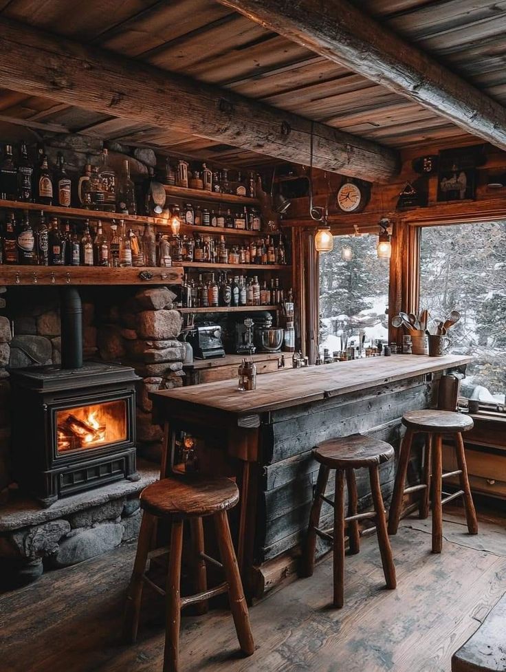 an old log cabin with wood burning stove and wooden stools in front of the bar