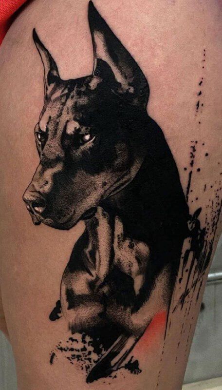 a black and white dog tattoo on the thigh