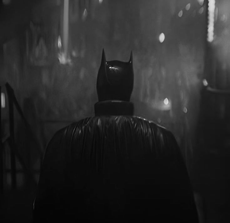 the dark knight in batman's cape is seen from behind as it stands on a stage