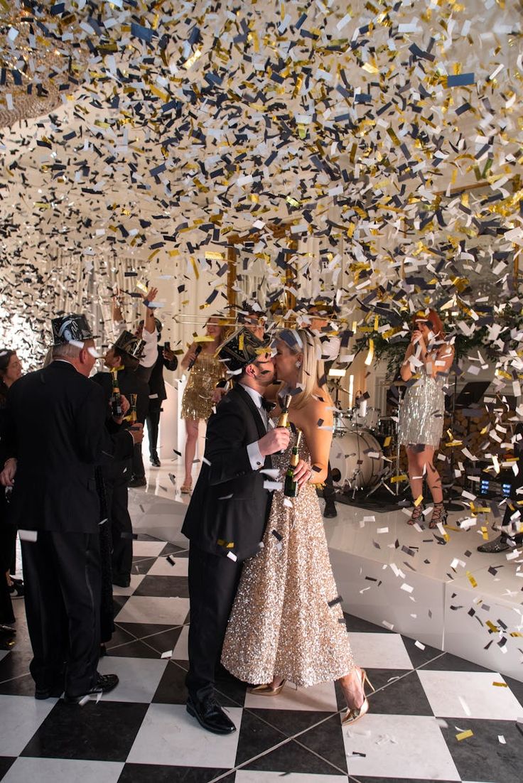 a man and woman are standing under confetti