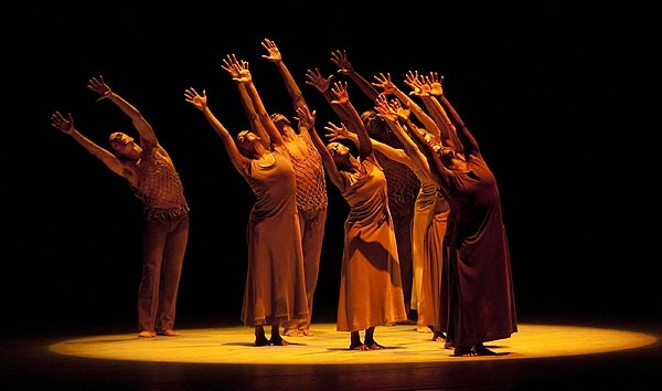 a group of people standing on top of a stage with their arms in the air