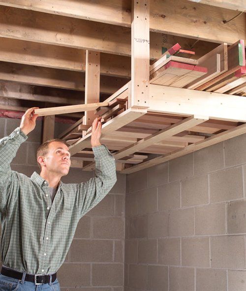 a man is working on the ceiling in his home under construction with wood beams and wooden slats