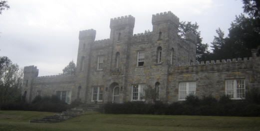 an old castle like building sitting on top of a lush green field