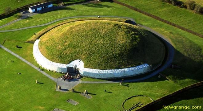 an aerial view of a large circular structure in the middle of a green field