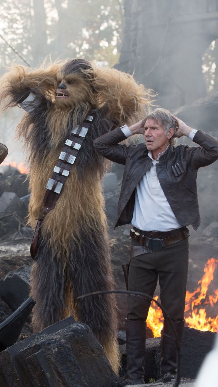 the star wars character has his hands on his ears as he stands in front of a fire