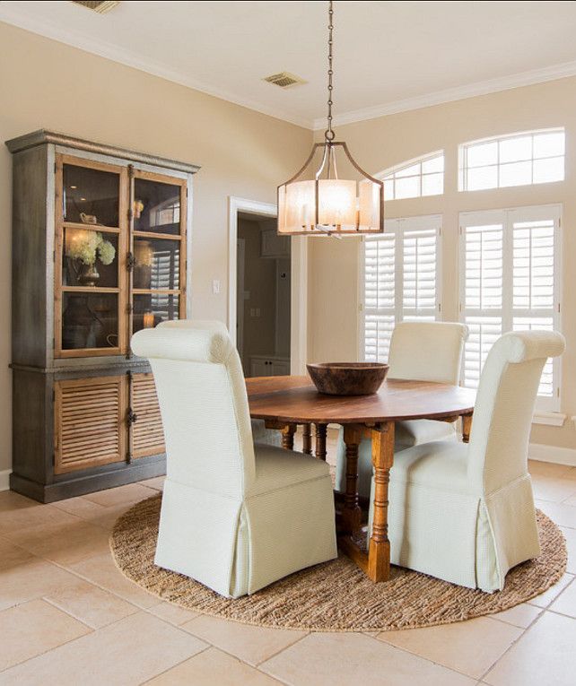 a dinning room table with chairs and a china cabinet in the back ground area