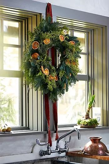 a wreath hanging from the side of a kitchen sink