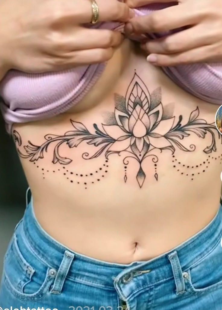 a woman's stomach with tattoos on it and the bottom part of her stomach