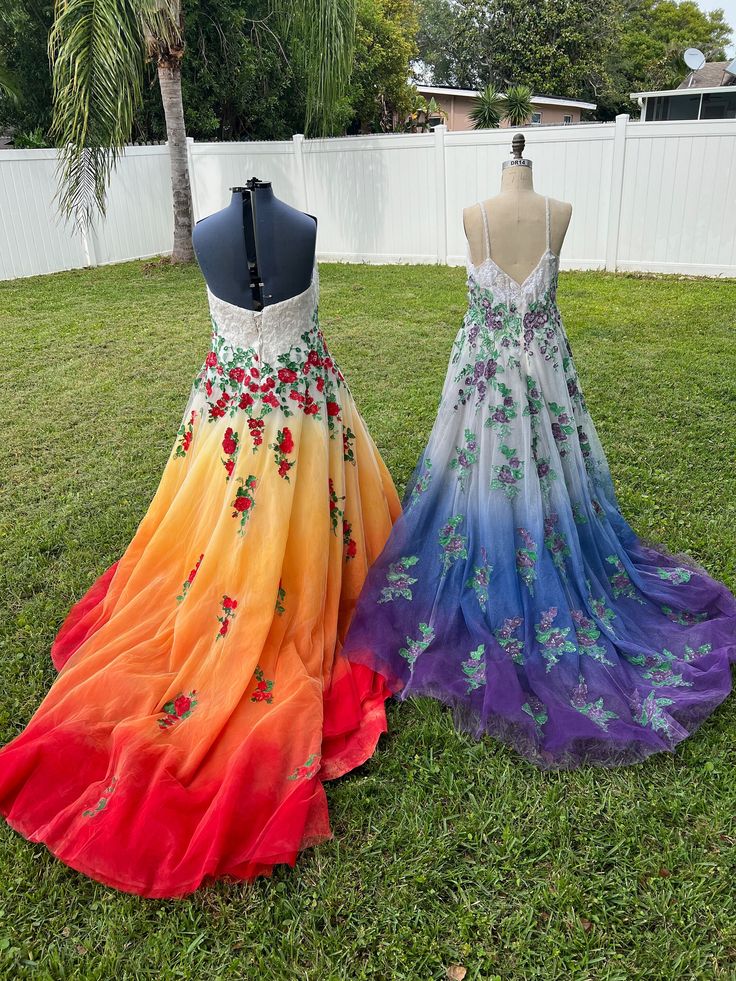 two dresses on mannequins in the grass