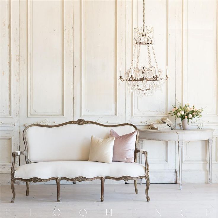 a white couch sitting next to a table with a chandelier