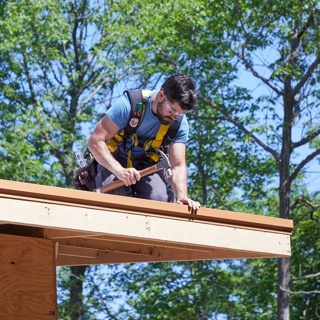 a man working on the roof of a house