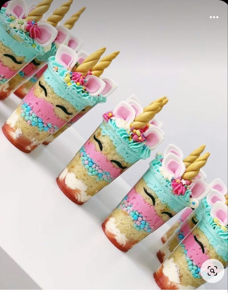 the unicorn desserts are decorated with blue, pink and yellow frosting on them