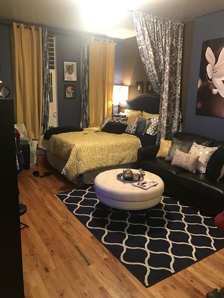 a living room filled with furniture next to a bed and a tv on top of a hard wood floor