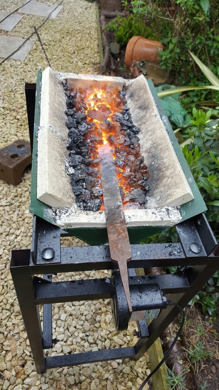 a large knife sitting on top of a stone block with flames coming out of it