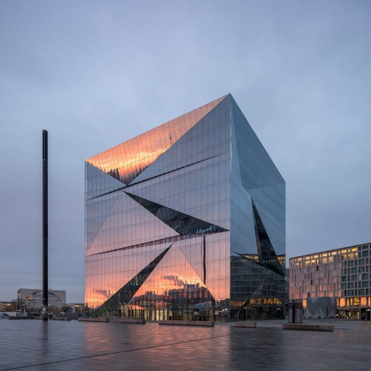 the building is made up of glass and has a triangular design on it's side