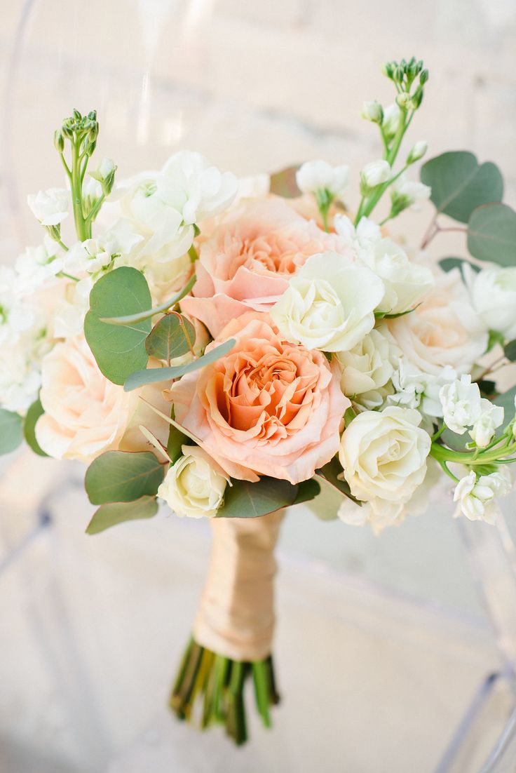 a bridal bouquet with peach and white flowers