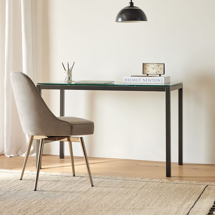 a desk with a chair and clock on it in front of a window that says west elm