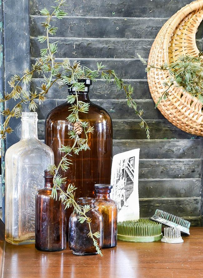 some bottles are sitting on a table next to a basket with plants and combs