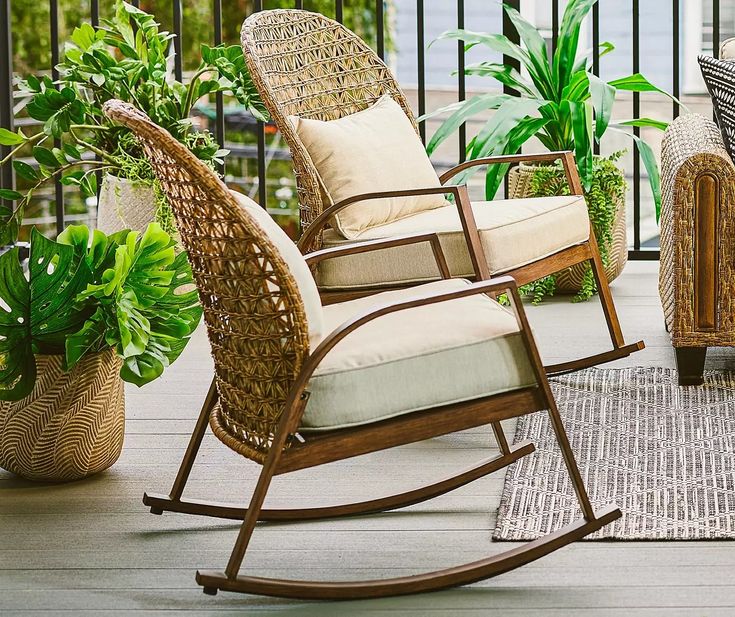 a rocking chair sitting on top of a wooden floor next to a potted plant