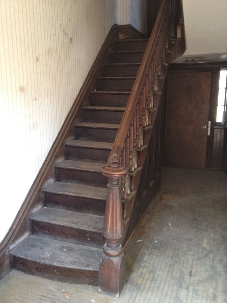 an old wooden stair case next to a wall