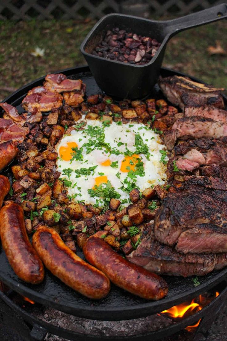 a grill with sausages, eggs and other foods on it next to some beans