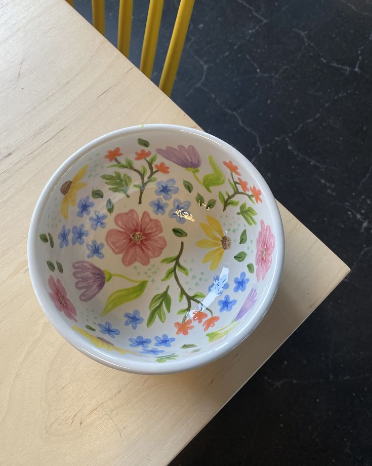 a colorful bowl sitting on top of a wooden table