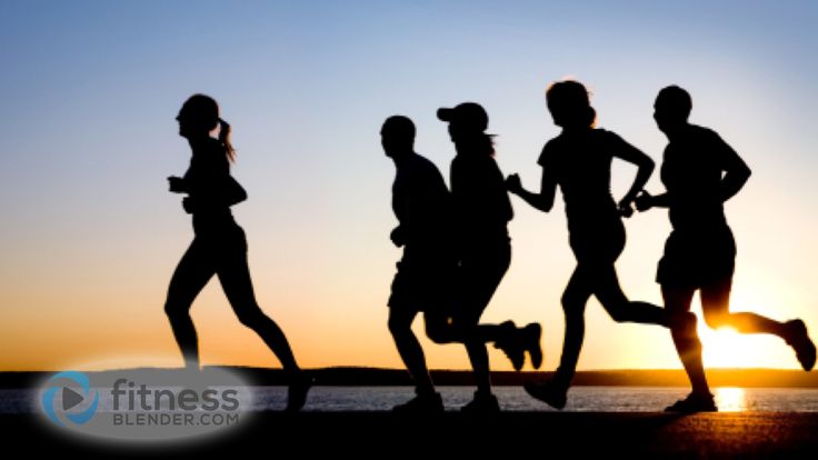 silhouettes of people running on the beach at sunset or sunrise with dog in foreground