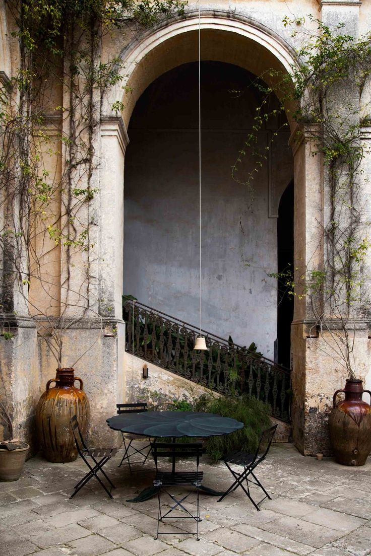 an outdoor table and chairs in front of a building