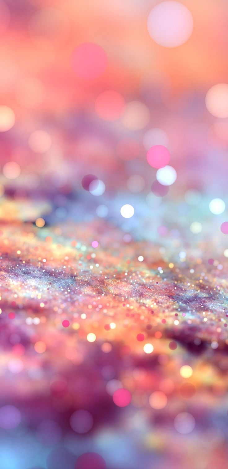 an abstract background with lots of glitter and blurry lights in pink, yellow and blue colors