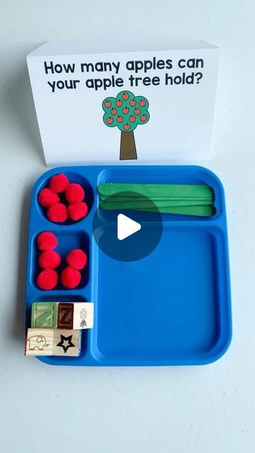 a blue tray with red apples on it next to a playdoughe game