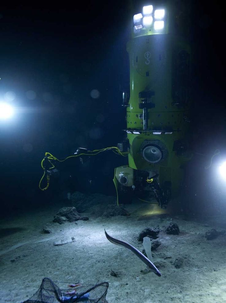 an underwater camera and some lights on the ground in the dark, with two flashlights attached to it