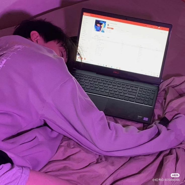 a man laying in bed with his head on the laptop