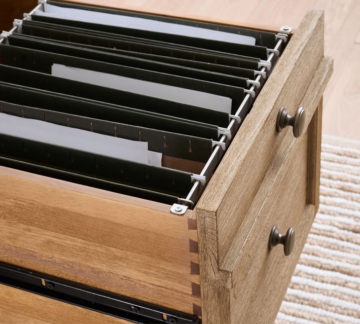 a wooden drawer with several files in it