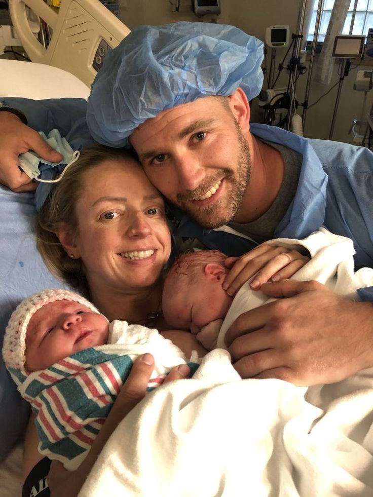 a man and woman holding a baby in a hospital bed