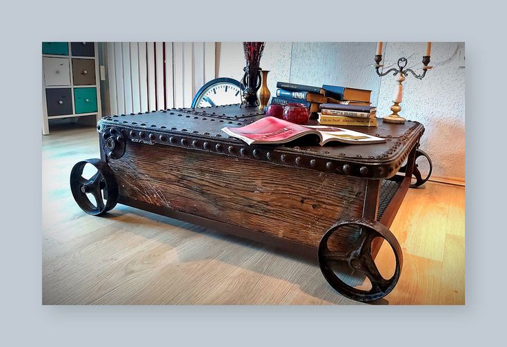 an old fashioned wooden cart with wheels and books on it's side, in front of a window