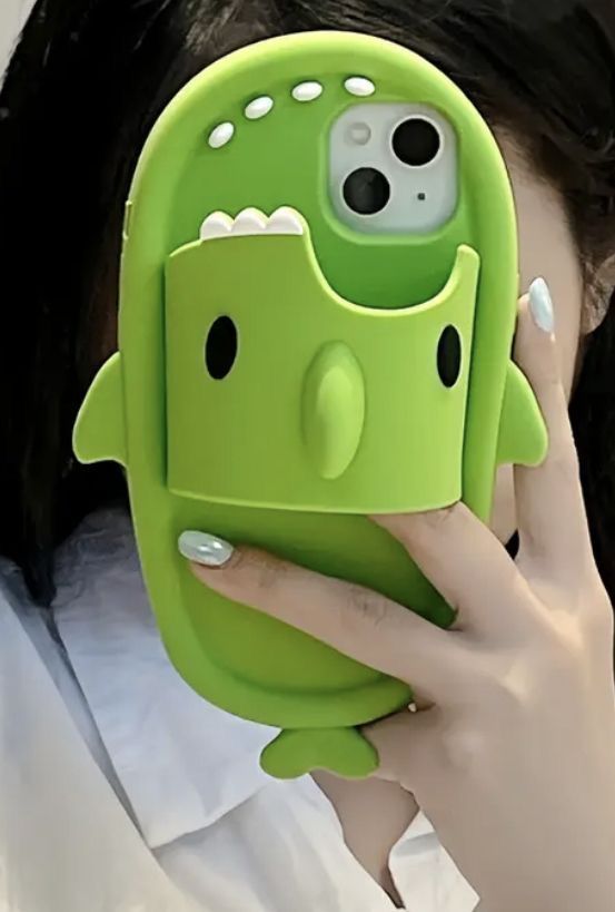 a woman holding up a cell phone case with a green monster design on the front