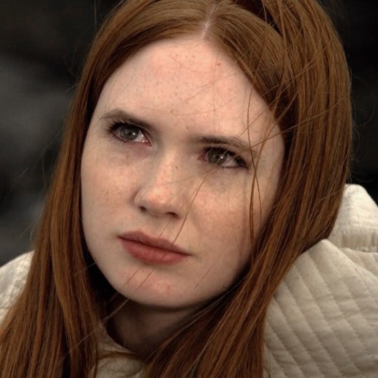 a close up of a person with red hair and freckles on her face