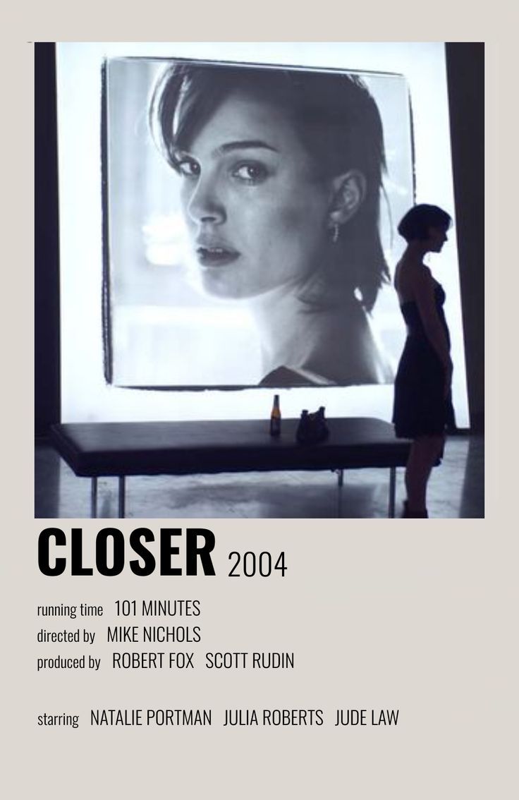 a woman standing in front of a large screen with the words closer on it's side