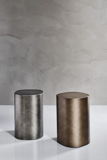 two metal stools sitting next to each other on a table