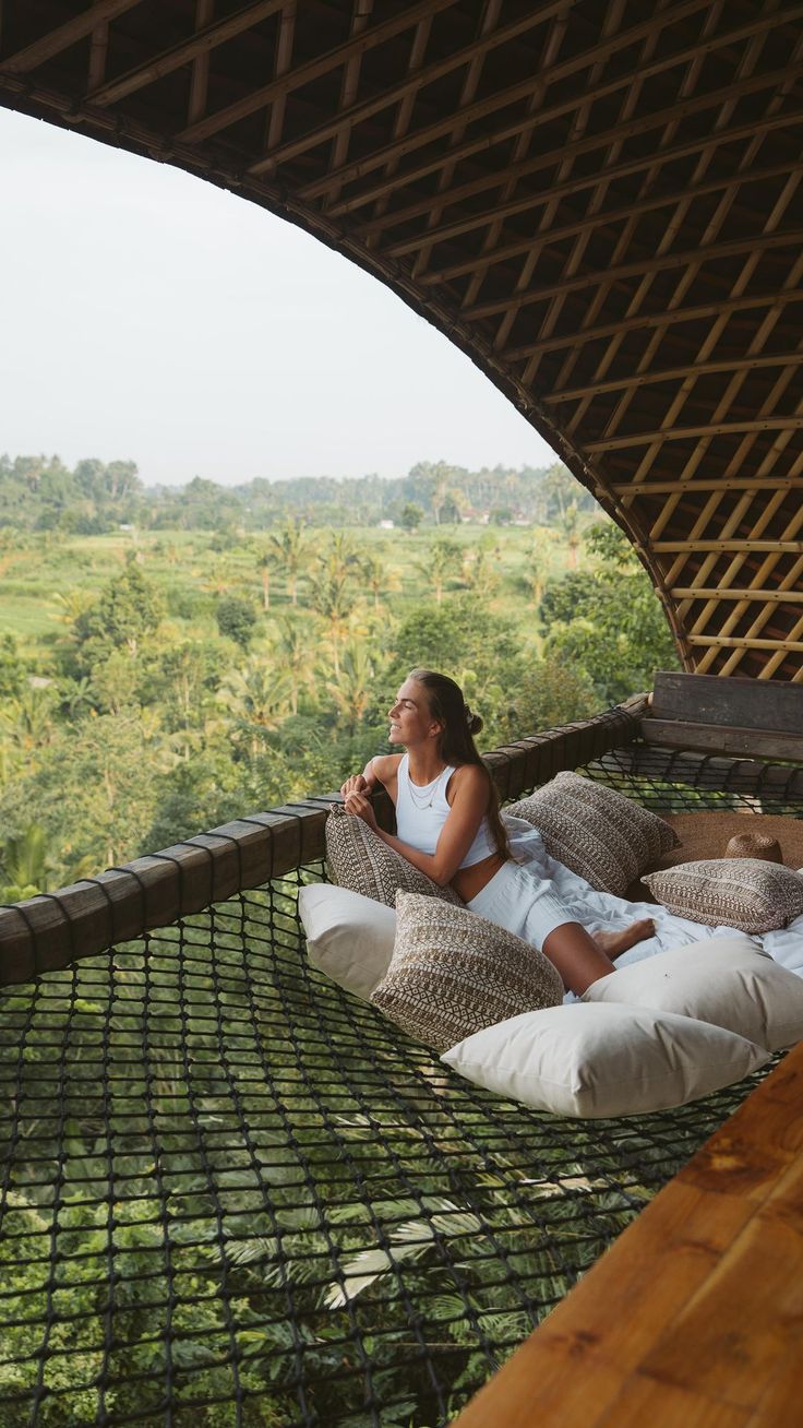 a woman sitting in a hammock on top of a hill