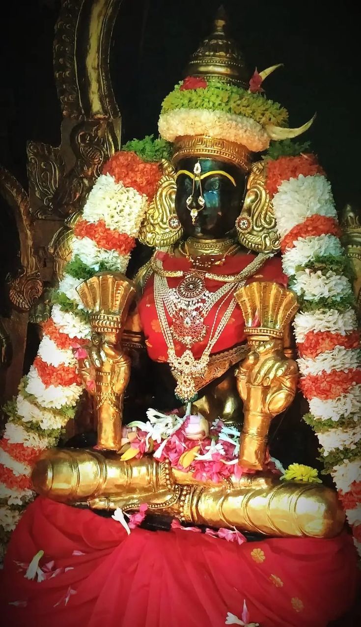 the statue is decorated with flowers and garlands