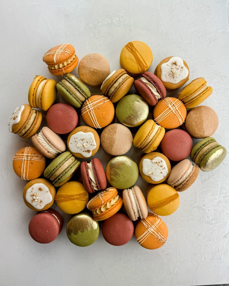 colorful macaroons arranged in the shape of a heart on a white table top