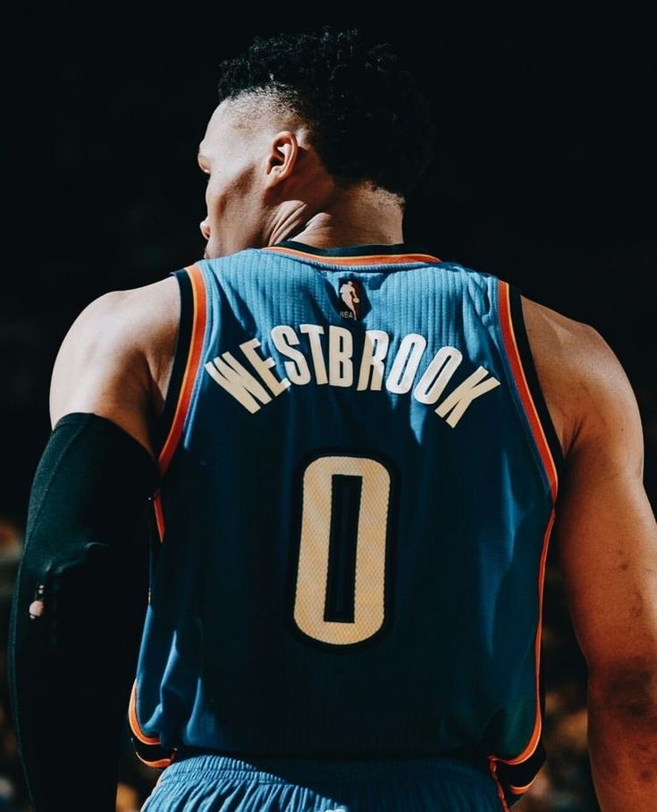 the back of a basketball player's jersey with his hand on his face,