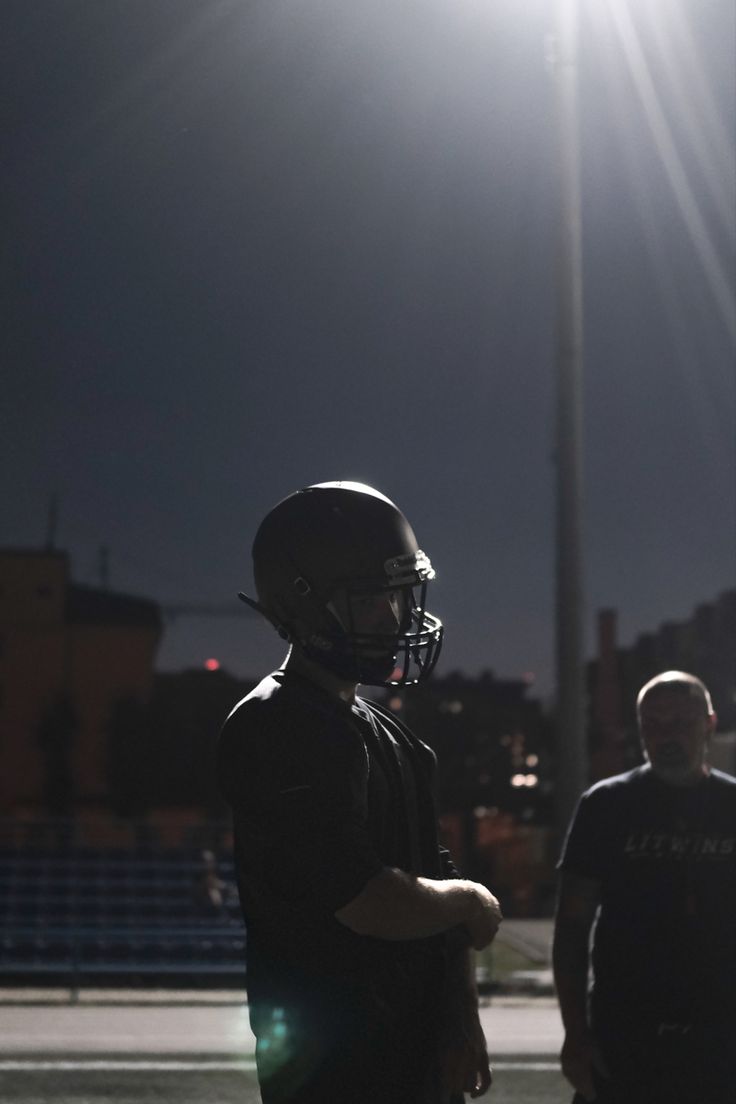 two football players standing next to each other on a field with the sun shining behind them