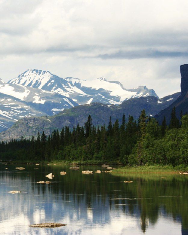 the mountains are reflected in the still water