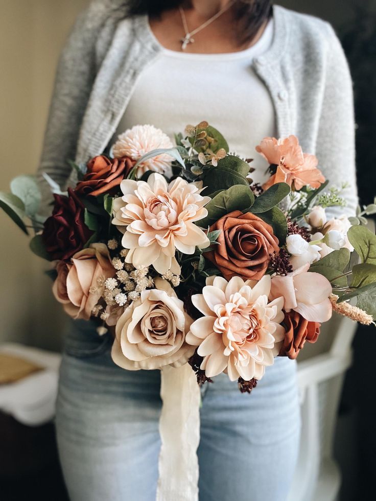 a woman holding a bouquet of flowers in her hands