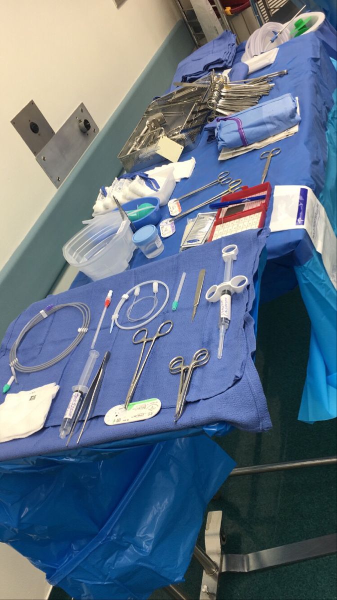 an operating table with surgical equipment on it's blue cloths and plastic bags