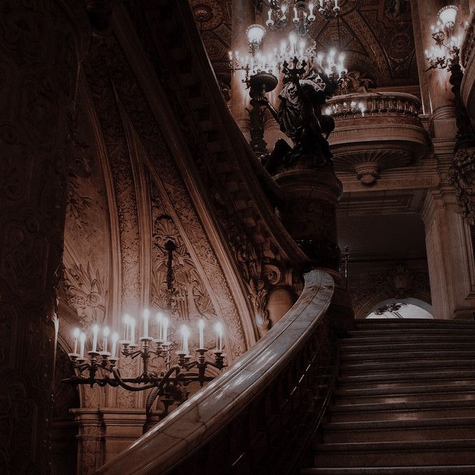 an ornate staircase with chandeliers and candles