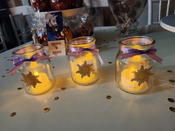 three mason jars with candles are sitting on a table